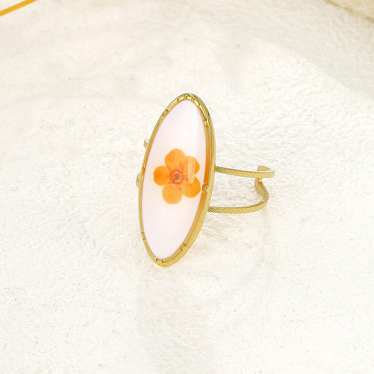 Bague dorée ovale blanche avec fleur orange