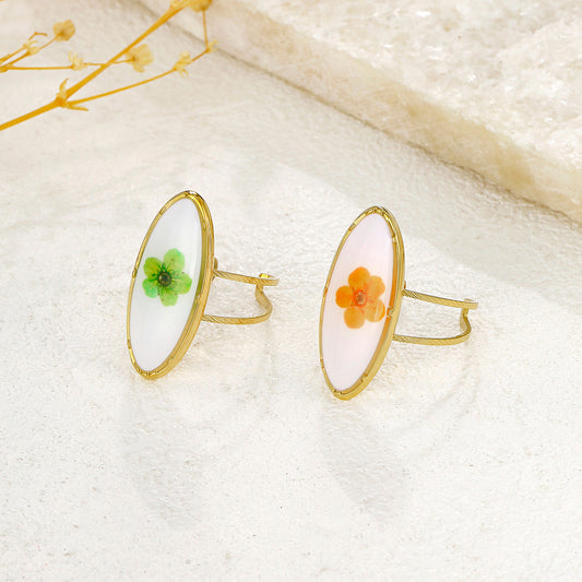 Bague dorée ovale blanche avec fleur verte