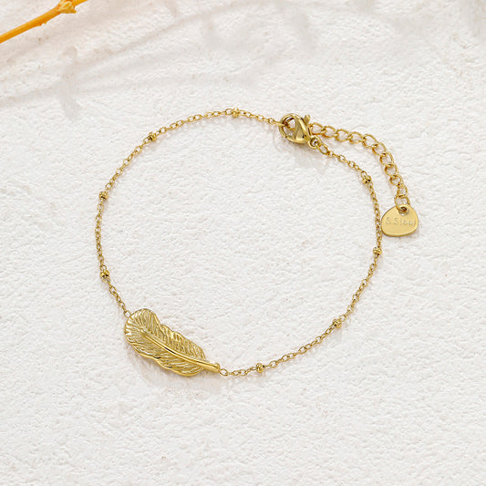 Bracelet doré chaîne fine pendentif plume texturé