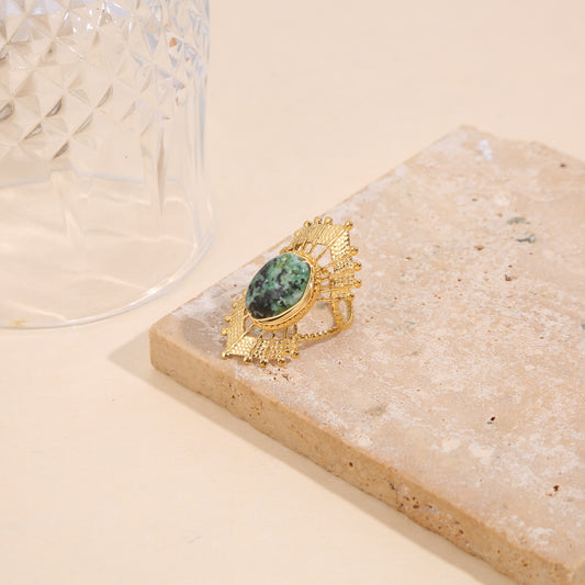 Bague dorée ajustable style solaire avec pierre ovale verte et détails ciselés
