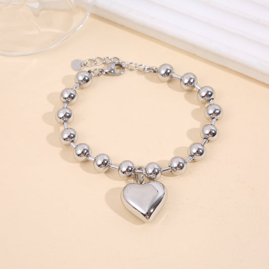 Bracelet argenté à grosses perles rondes avec pendentif cœur bombé