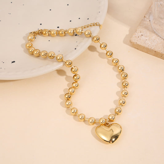 Collier doré boules pendentif grand cœur bombé