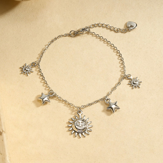 Bracelet chaîne fine argentée pendentifs soleil central encadré par étoiles et soleils