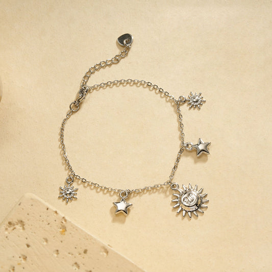 Bracelet chaîne fine argentée pendentifs soleil central encadré par étoiles et soleils