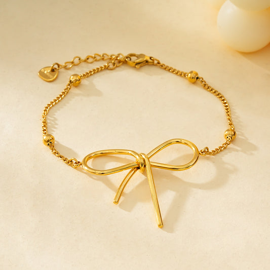 Bracelet Doré Chaîne Ornée de Boules Dorées Avec Grand Nœud Papillon