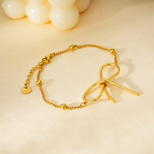 Bracelet Doré Chaîne Ornée de Boules Dorées Avec Grand Nœud Papillon