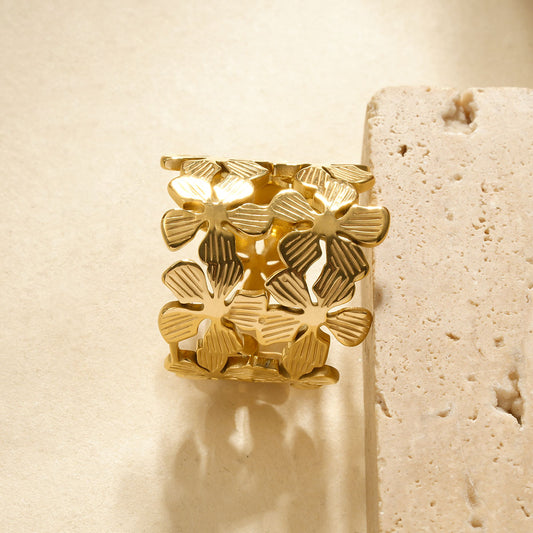 Bague dorée large composée de 2 rangées de fleurs ajourées à pétales rainurés