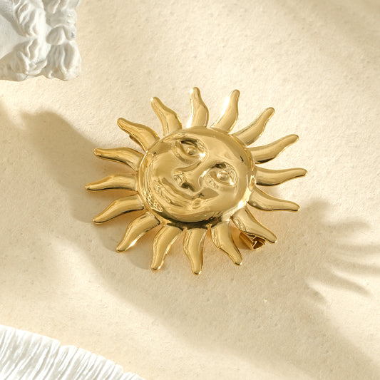 Broche dorée soleil décoratif au visage expressif