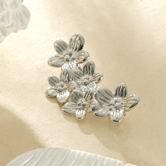 Broche composée de cinq fleurs sculpturales de tailles différentes