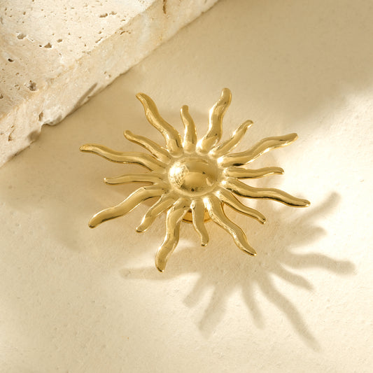 Broche dorée aimantée en forme de soleil avec des rayons