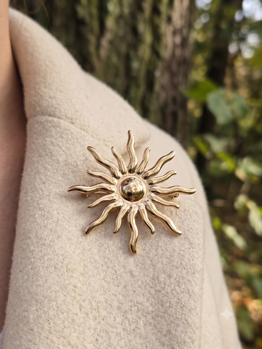 Broche dorée aimantée en forme de soleil avec des rayons