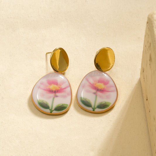 Boucles d'oreilles dorée pendantes avec fleur dessinée