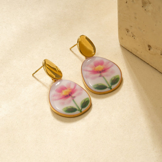 Boucles d'oreilles dorée pendantes avec fleur dessinée