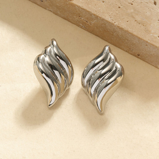 Boucles d’oreilles argentées en forme de flamme ondulée à relief bombé finition miroir