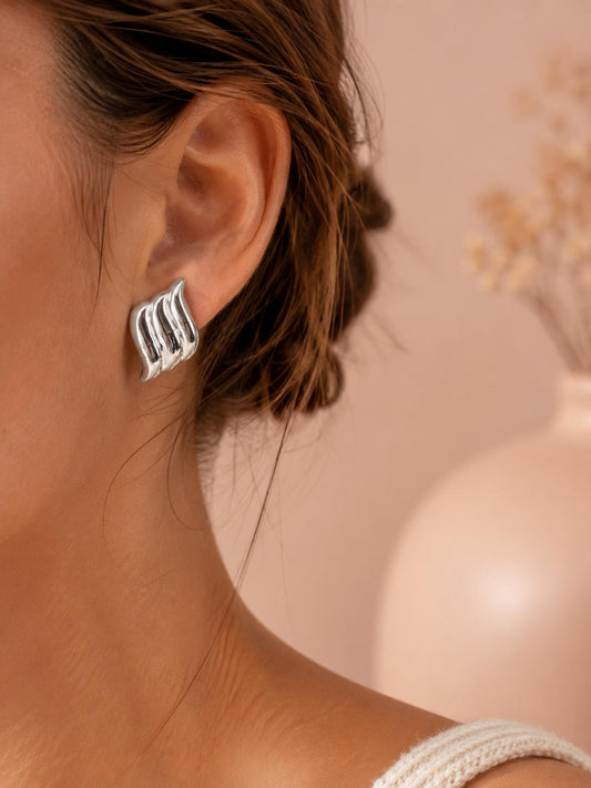 Boucles d’oreilles argentées en forme de flamme ondulée à relief bombé finition miroir