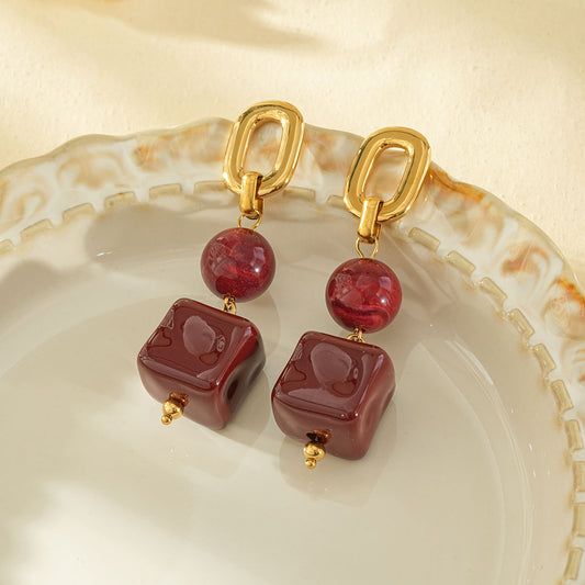 Boucles d'oreiles dorées pendantes résine rouge