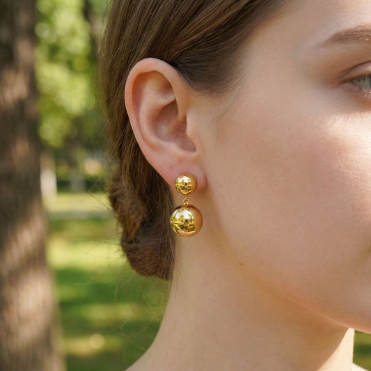 Boucles d'oreilles dorées pendantes double sphère polie