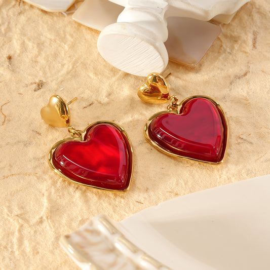 Boucles d'oreilles dorées pendantes cœurs résine rouge