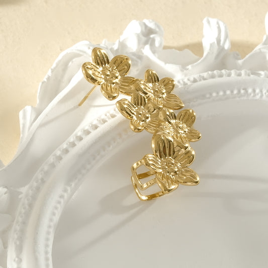 Bijou d’oreille doré avec cinq fleurs à cinq pétales de tailles différentes côté droit