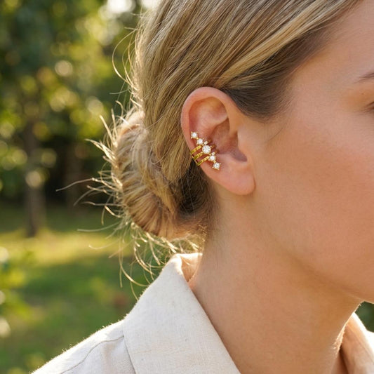Bijou d’oreille doré ajustable à trois anneaux superposés rehaussés d’une ligne de strass sertis