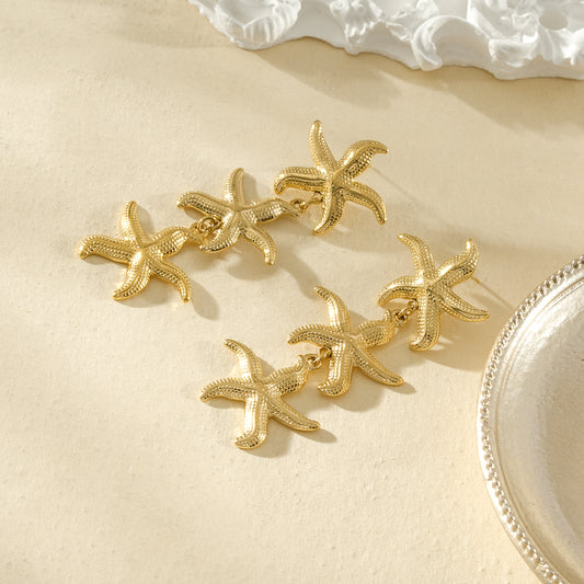 Boucles d’oreilles dorées trois étoiles de mer pendantes