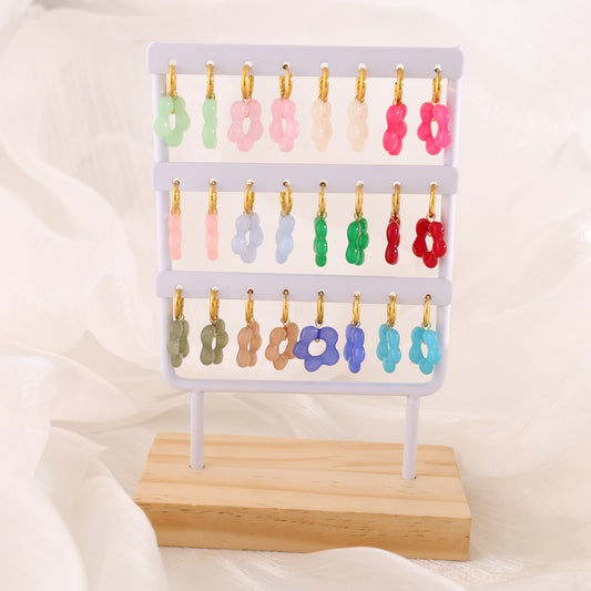Lot de boucles d'oreilles créoles fleur résines colorées sur présentoir blanc