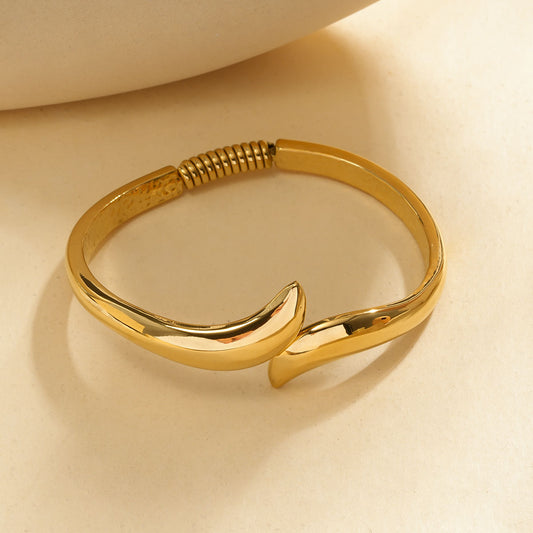 Bracelet jonc carré arrondi doré ouvert aux extrémités effilées en pointe et détail spiralé au dos