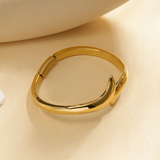 Bracelet jonc carré arrondi doré ouvert aux extrémités effilées en pointe et détail spiralé au dos