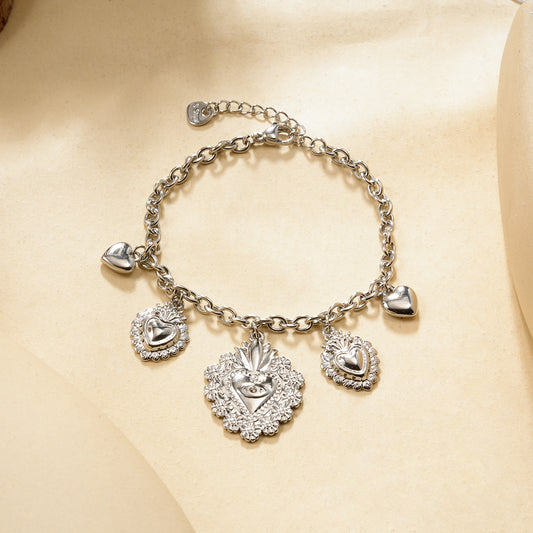 Bracelet chaîne argentée à charms cœurs bombés et ex-voto ciselés