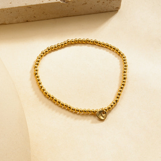 Bracelet élastique doré billes lisses effet miroir