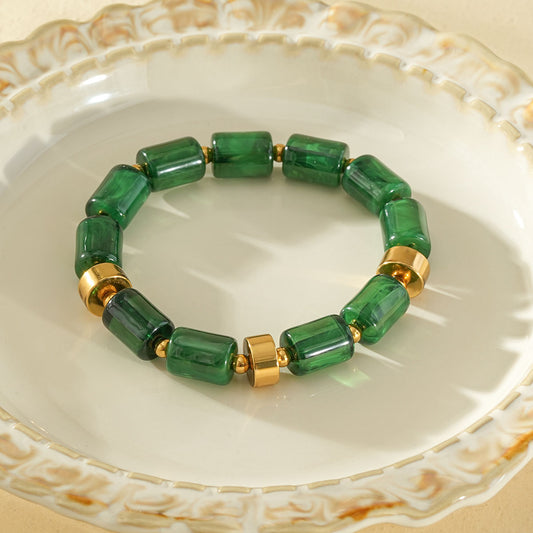 Bracelet élastique résine cylindrique vert ambré anneaux séparateurs dorés