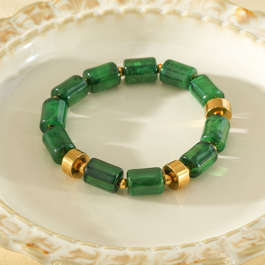 Bracelet élastique résine cylindrique vert ambré anneaux séparateurs dorés