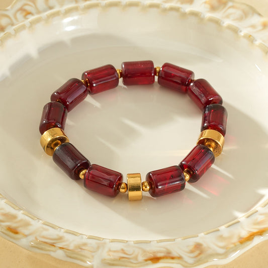 Bracelet élastique résine cylindrique rouge ambré anneaux séparateurs dorés