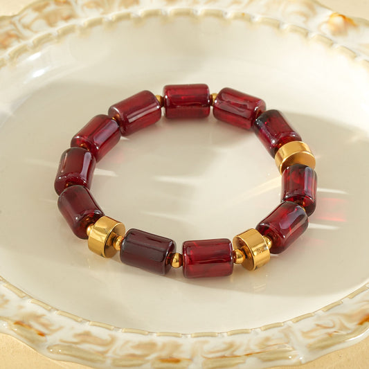 Bracelet élastique résine cylindrique rouge ambré anneaux séparateurs dorés