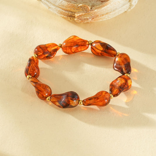 Bracelet élastique résine formes irrégulières marron ambré séarateurs dorés