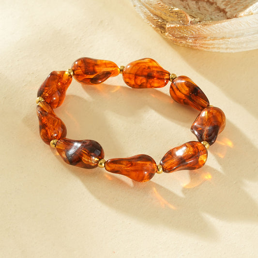 Bracelet élastique résine formes irrégulières marron ambré séarateurs dorés
