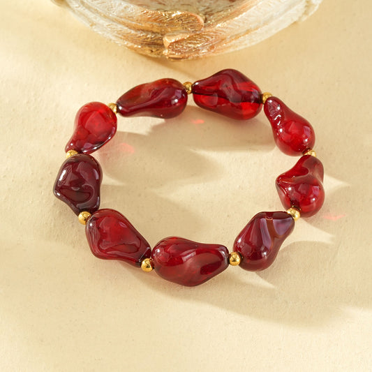 Bracelet élastique résine formes irrégulières rouge ambré séarateurs dorés