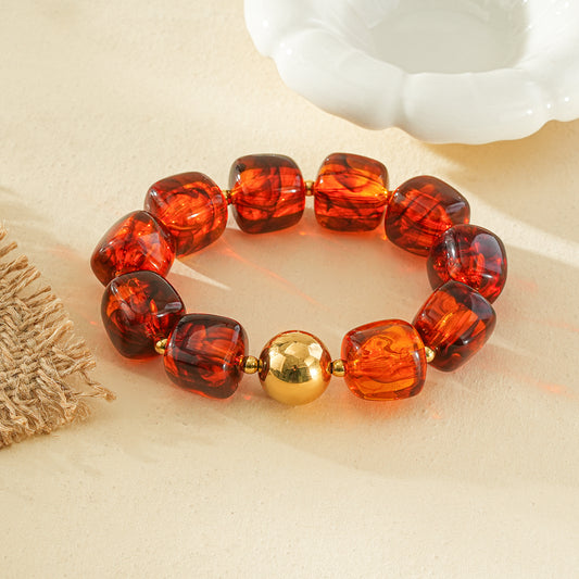 Bracelet élastique résine forme géométrique marron ambré et billes dorées