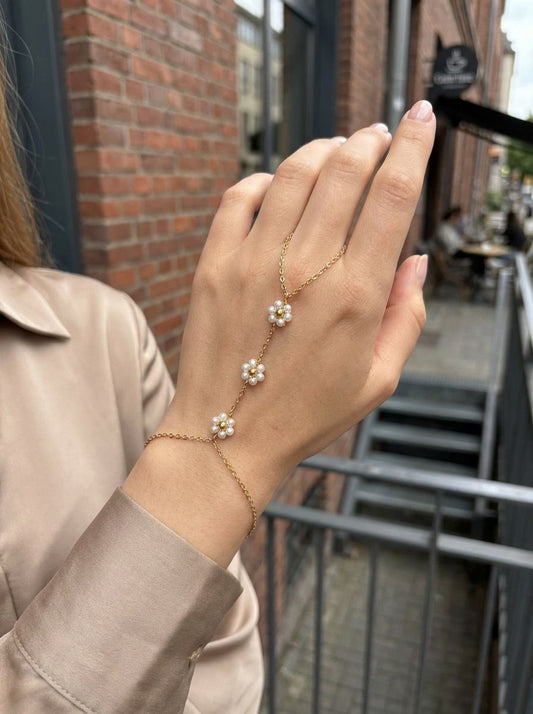 Chaîne de main dorée fine à double anneau ornée de perles blanches