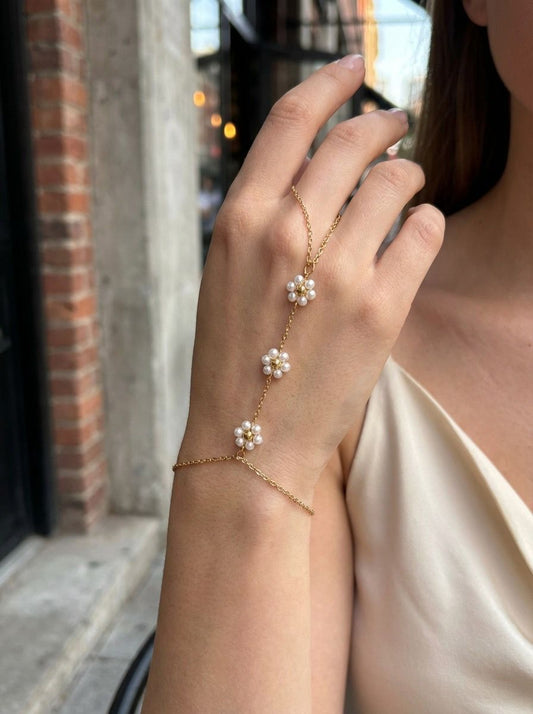 Chaîne de main dorée fine à double anneau ornée de perles blanches