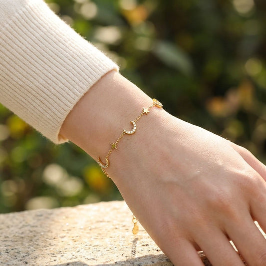 Bracelet doré à chaîne fine orné de lunes strassées et de petites étoiles