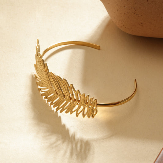 Manchette dorée ouverte motif feuille tropicale