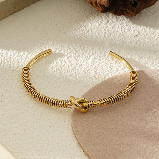 Bracelet Jonc Ouvert Doré Effet Ressort Avec Nœud Central