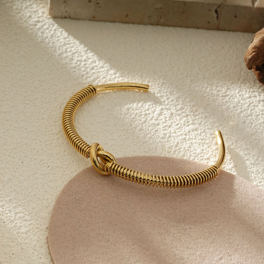 Bracelet Jonc Ouvert Doré Effet Ressort Avec Nœud Central