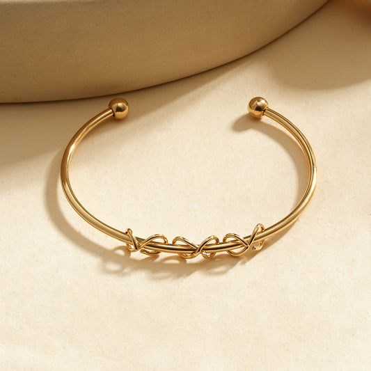 Bracelet manchette dorée ouverte motif nœuds entrelacés