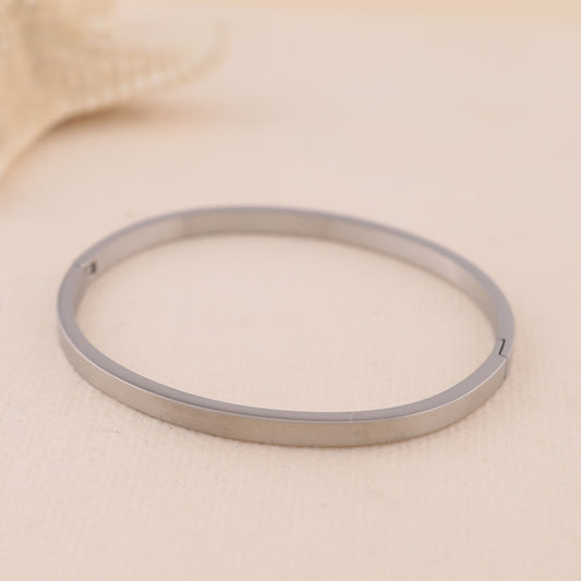 Bracelet jonc fin oval argenté fermé à bordure carrée et fermoir discret