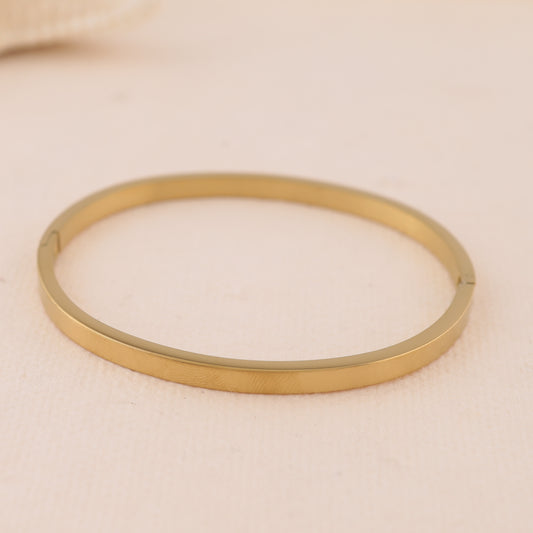 Bracelet jonc fin oval doré fermé à bordure carrée et fermoir discret