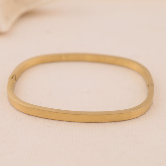 Bracelet jonc fin rectangulaire arrondi doré fermé à bordure carrée et fermoir discret