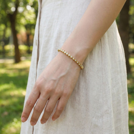 Bracelet jonc doré orné de forme rondes et losanges strassés