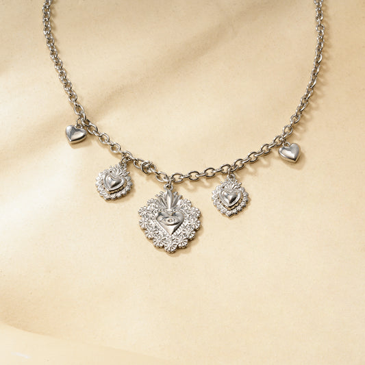 Collier chaîne argentée à charms cœurs bombés et ex-voto ciselés